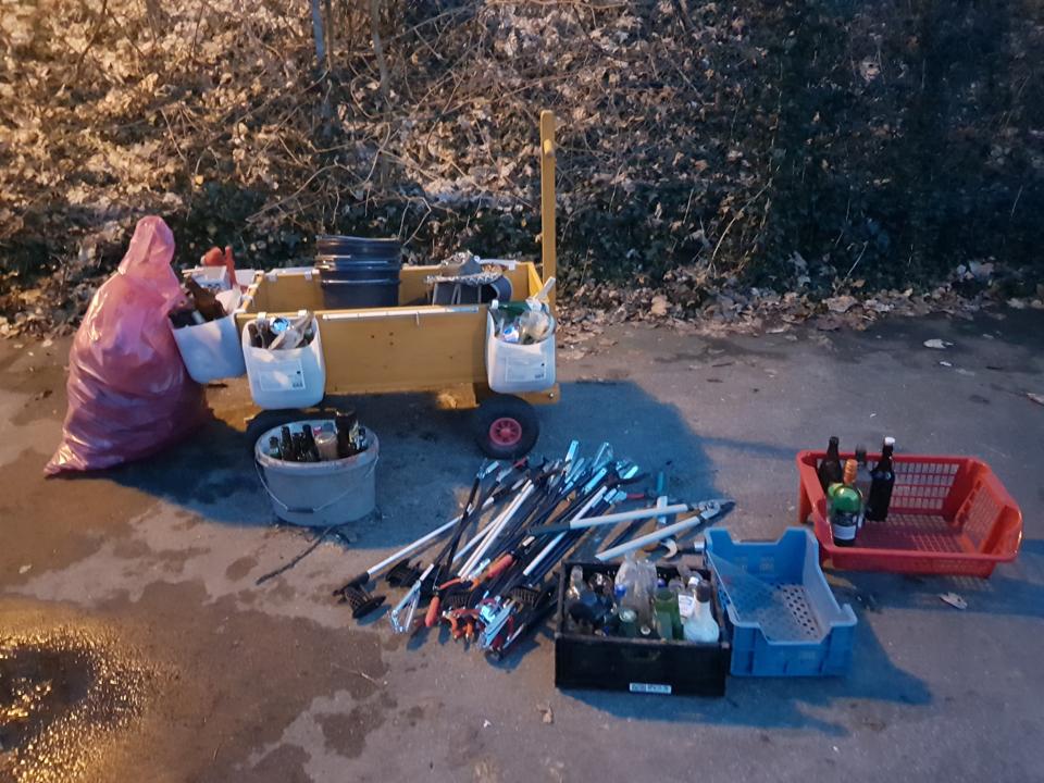 Waste-Buster mit Zangen und Pfandflaschen, sowie Eimern gefuellt mit Altglas.