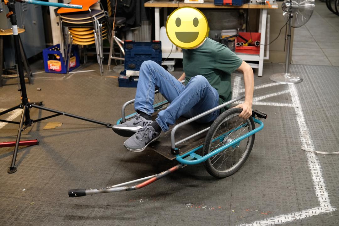 Jemand aus dem Team versucht die Balance mit dem Anhaenger zu halten.
