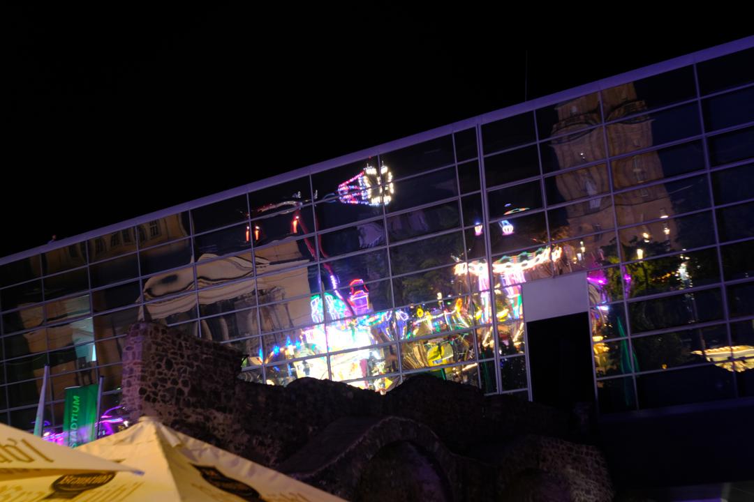 An der Glasfassade des Darmstadtium spiegelt sich ein Teil des Heinerfests.
